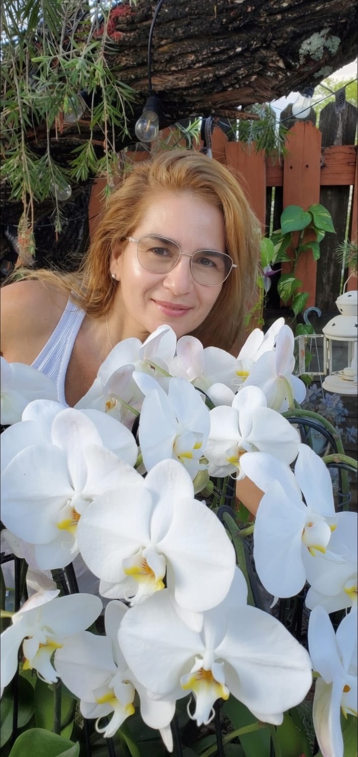 Carol surrounded by white phalaenopsis orchids
